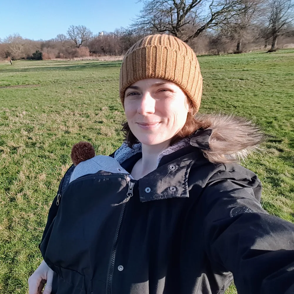 Elodie se promenant dans un parc de l'est de Londres, son bébé en portage